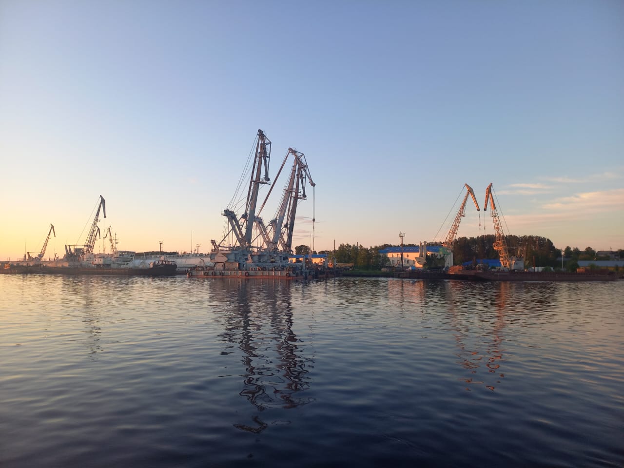 Причал и краны промышленной базы в Игриме на закате